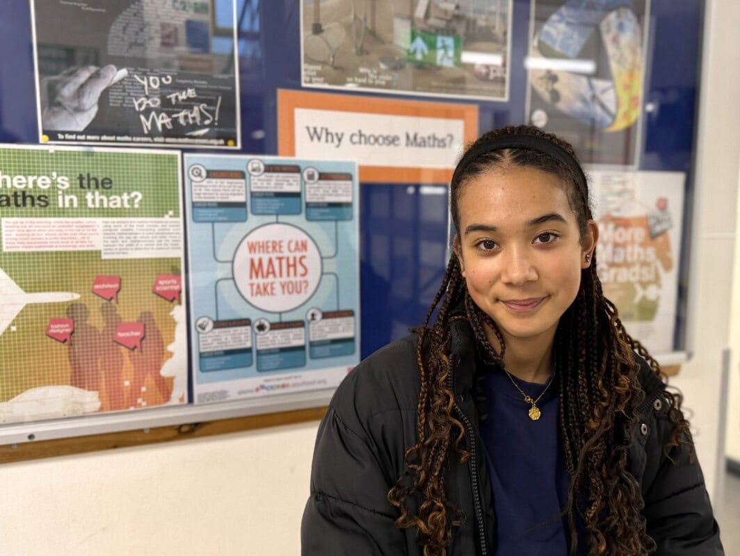 female student Alyssa sitting in front of a Maths board